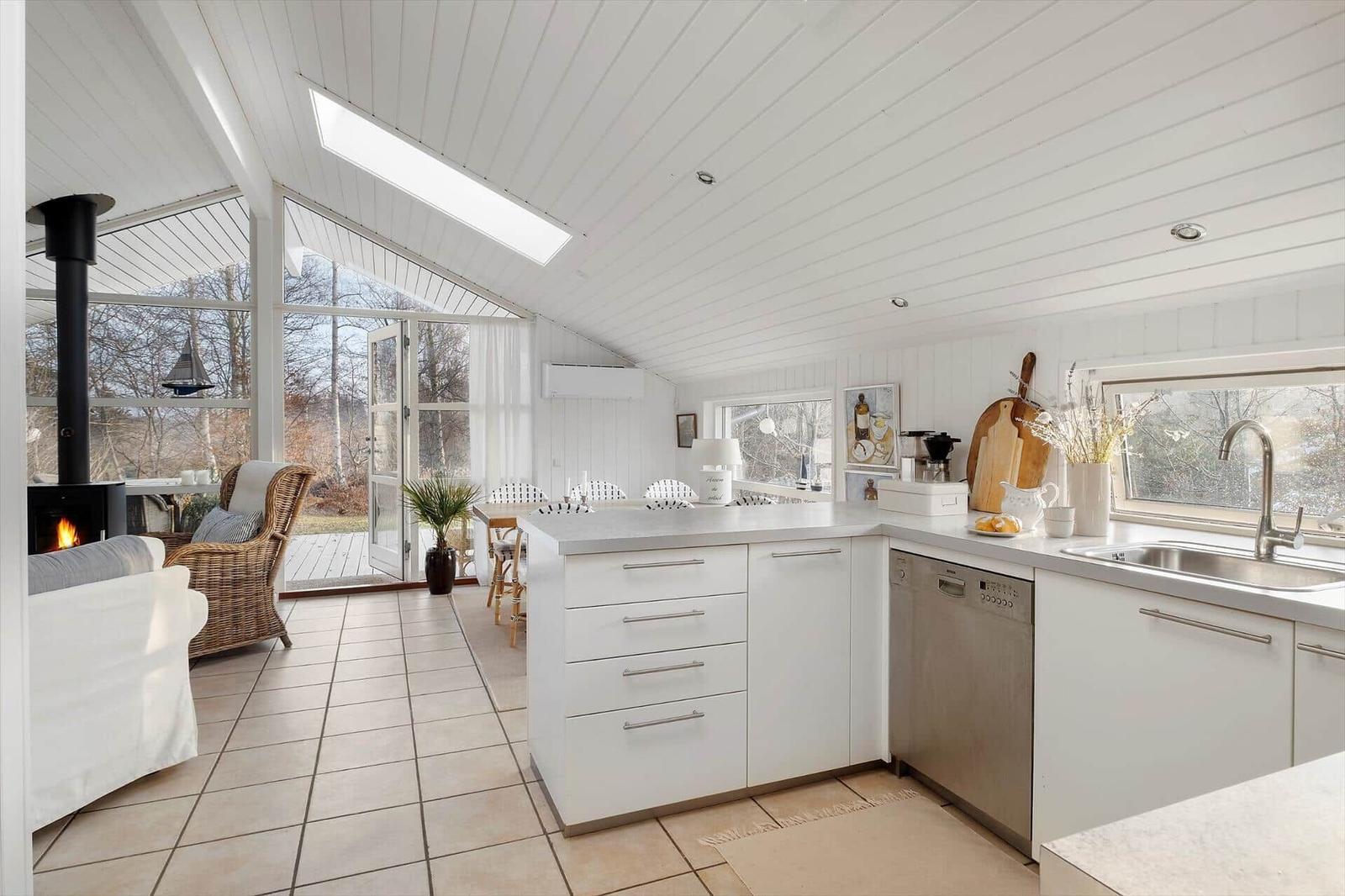 Kitchen with white built-in cabinetry, sink, and view to terrace