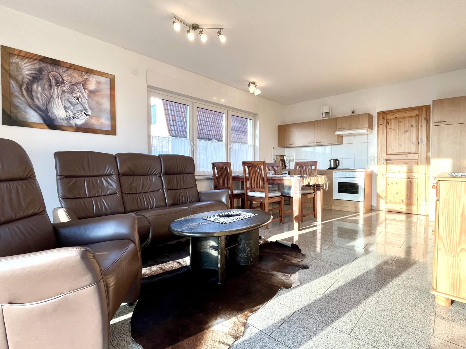 Wohnzimmer mit Essbereich und Küche mit Geschirrspüler