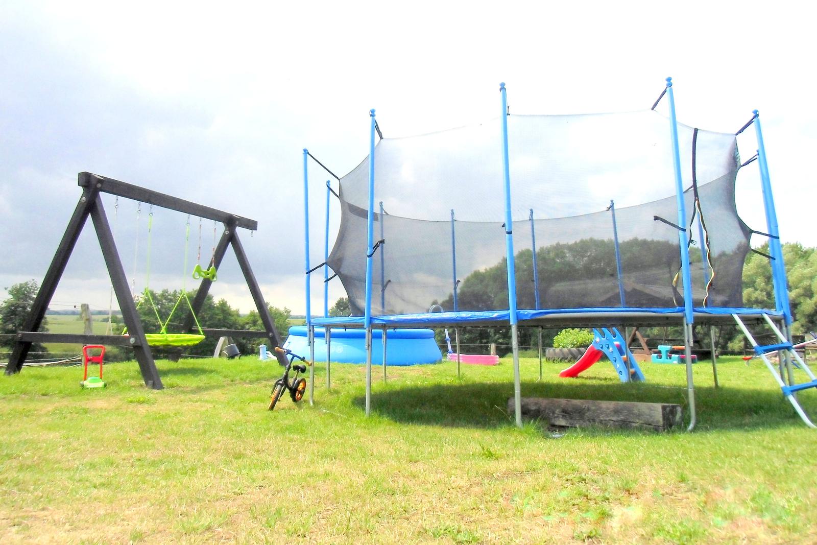 Spielplatz mit großem Trampolin und Pool im Sommer