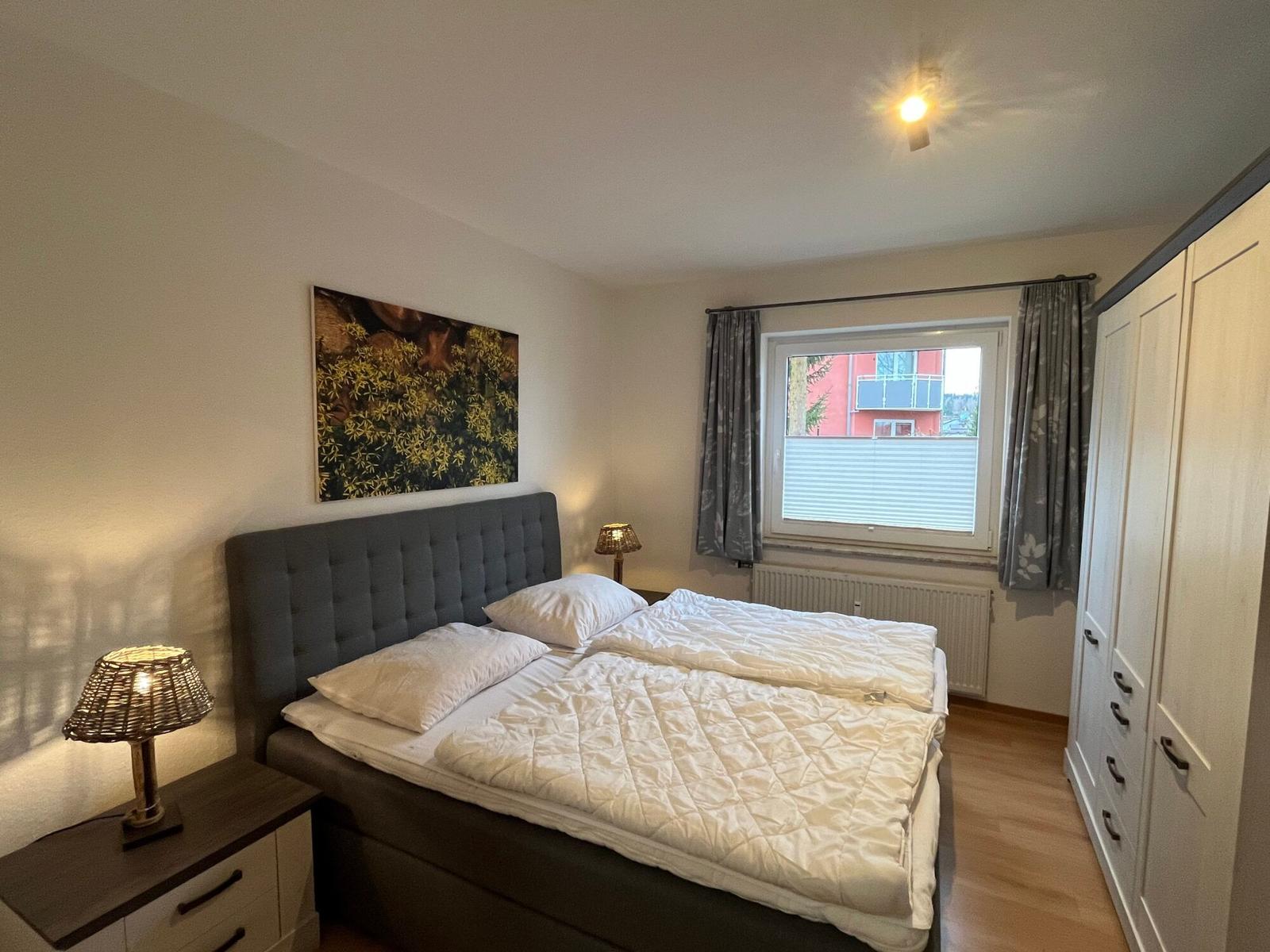 Schlafzimmer mit Doppelbett, Nachttischen und Kleiderschrank.