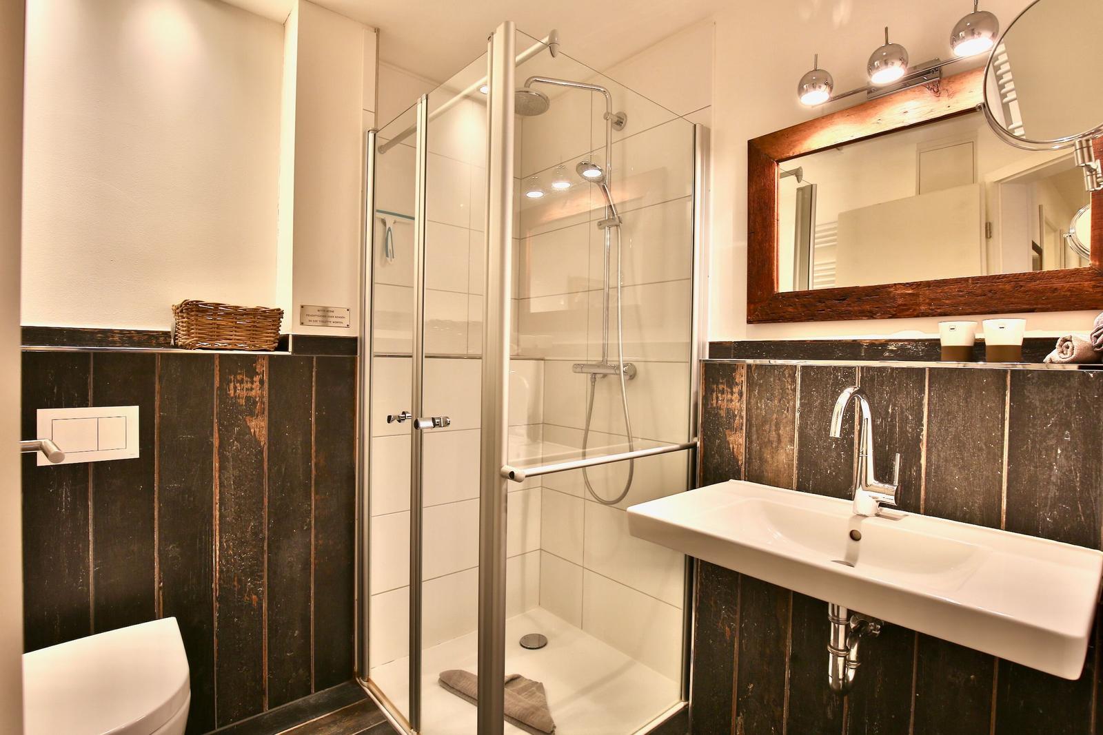 Bad mit Dusche, Waschbecken und Spiegel