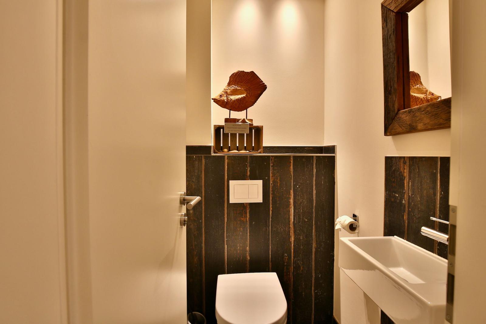 Bad mit Toilette, Waschbecken und Holzdekoration.