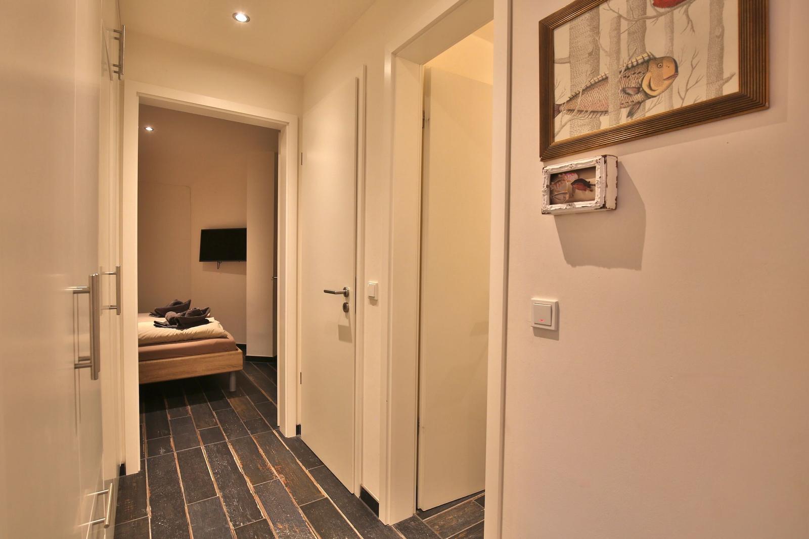 Flur mit Schlafzimmer und Tür. Wandbild mit Fischmotiv.
