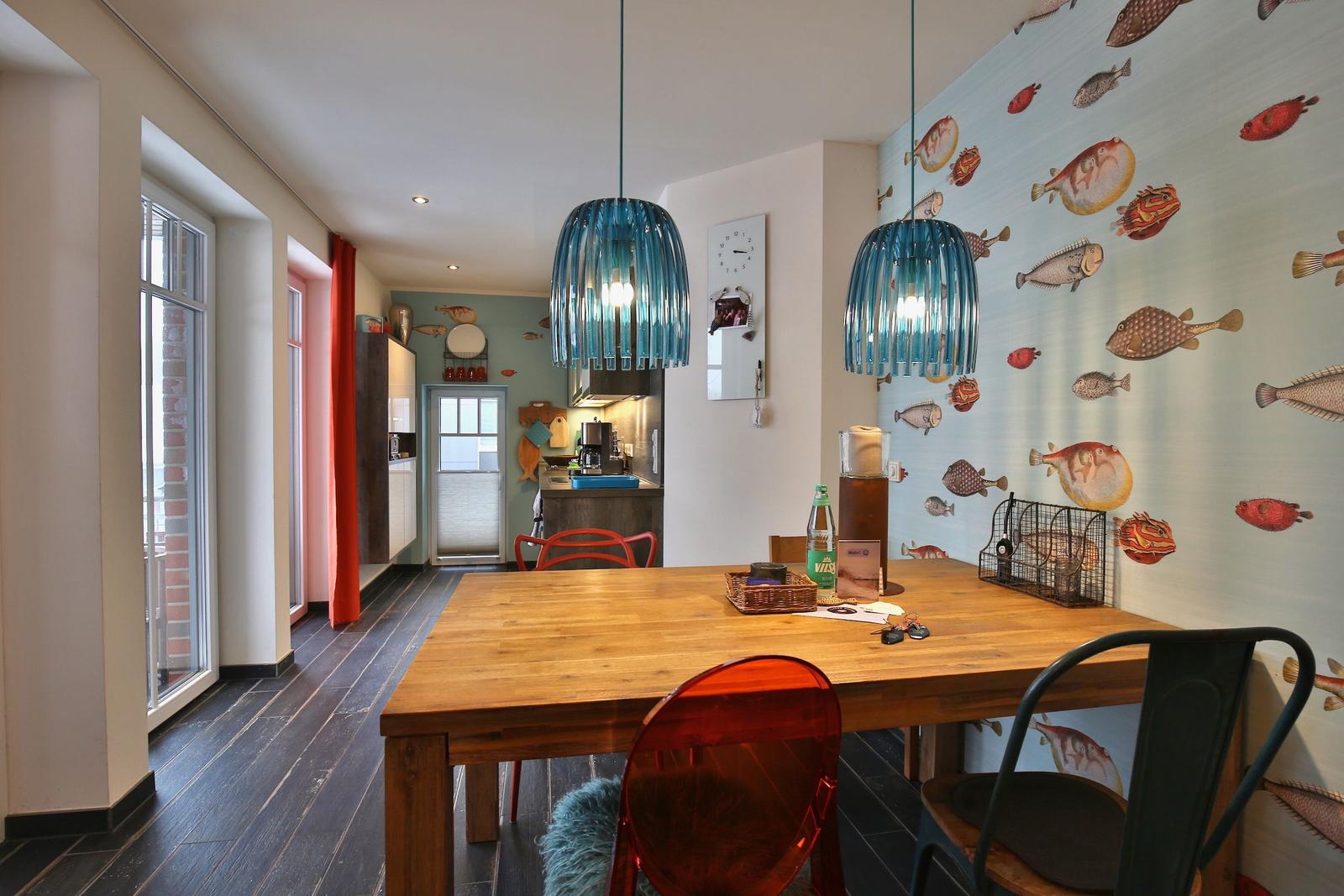 Essbereich mit Holztisch, Fisch壁纸 und blauen Hängelampen.