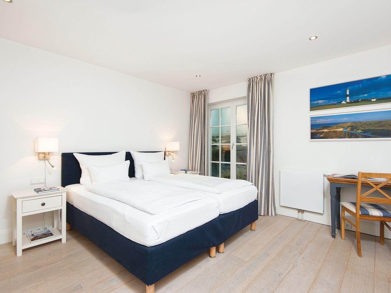 Bedroom with double bed, desk, and window with view.