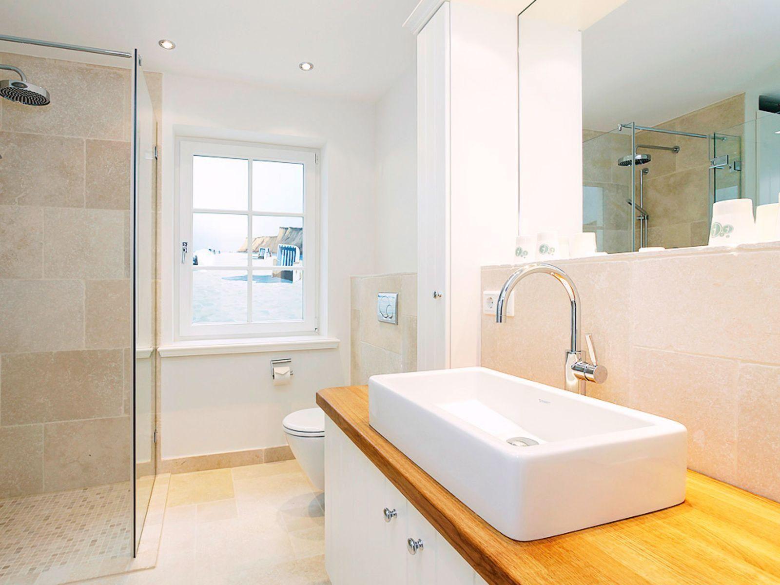 Bathroom with shower, sink, and window to pool