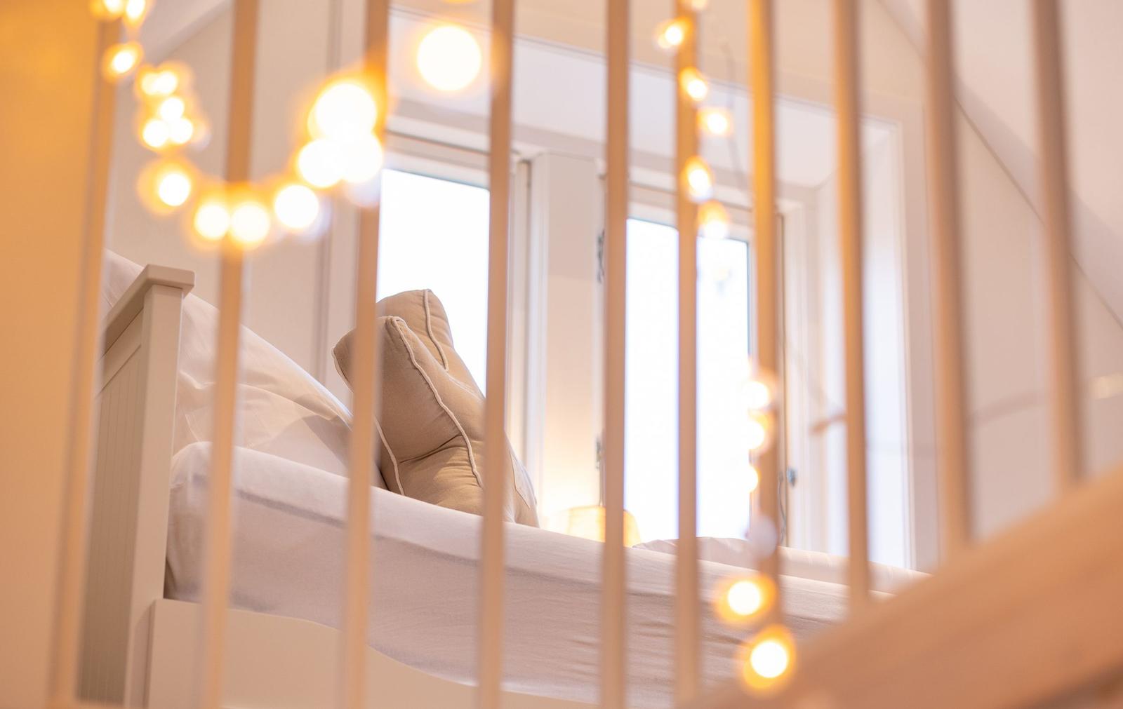 Schlafzimmer mit Bett, Kissen und Lichterkette.