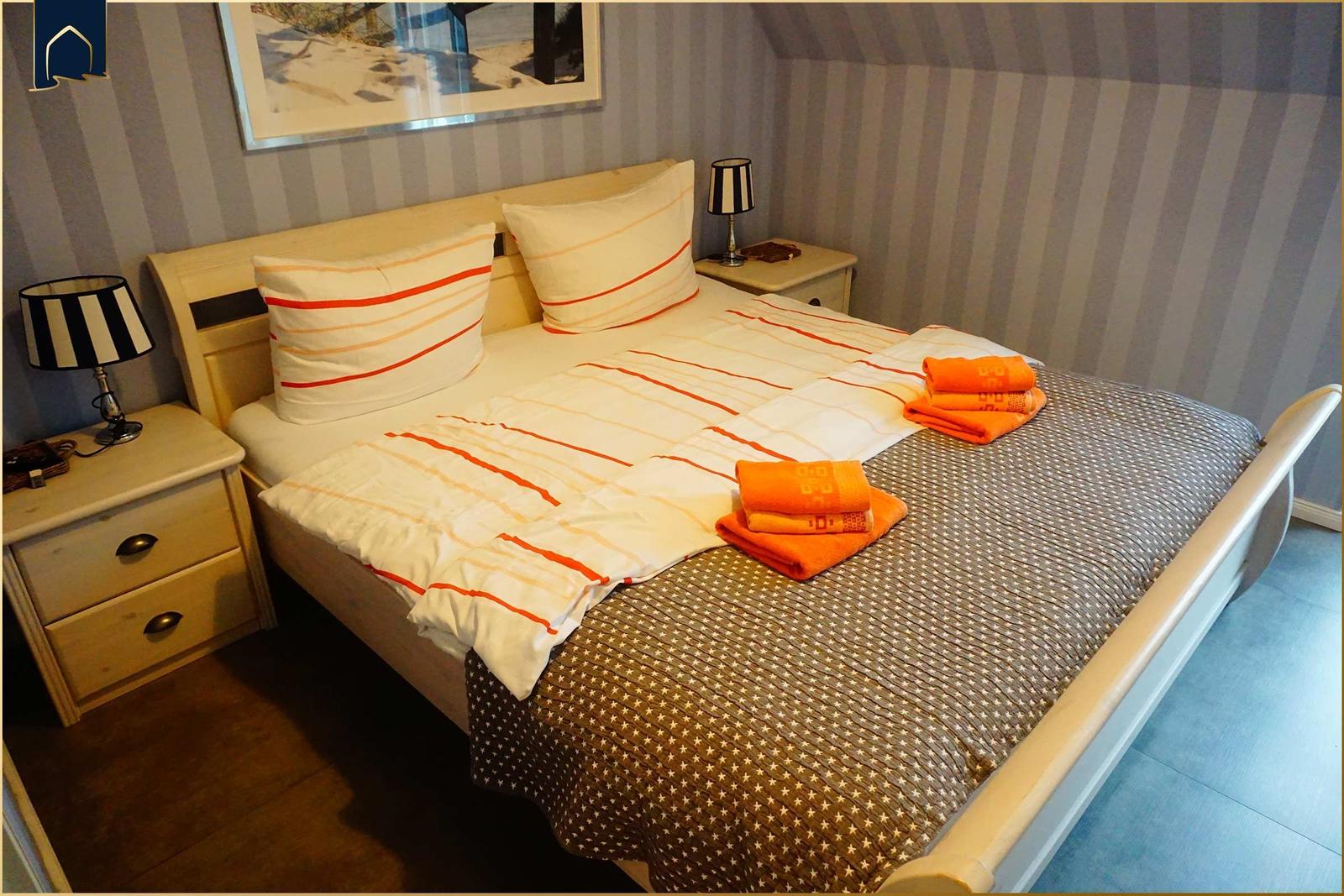 Schlafzimmer mit Bett, Nachttischen und Wandbild