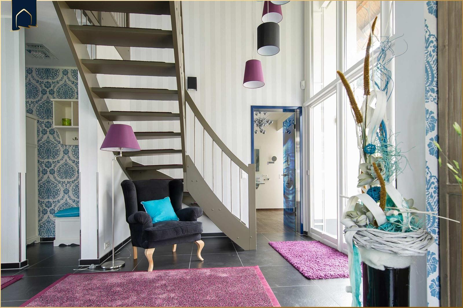 Haus mit Treppenhaus, Sitzgelegenheit und großen Fenstern.