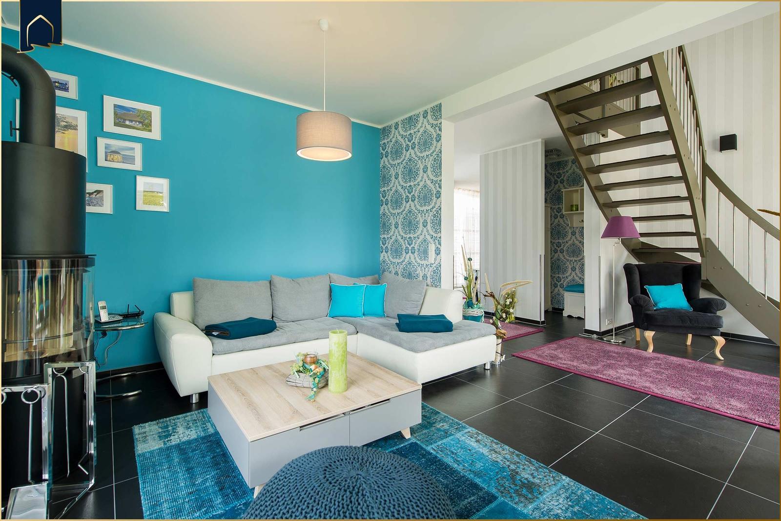 Wohnzimmer mit Sofa, Kamin und Treppe