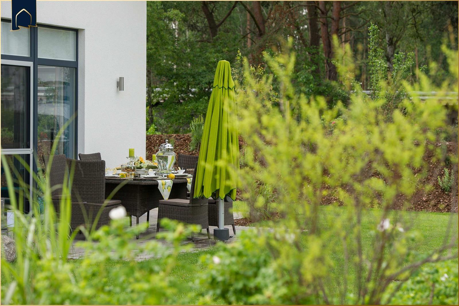 Gartenbereich mit gedecktem Tisch und grünem Sonnenschirm