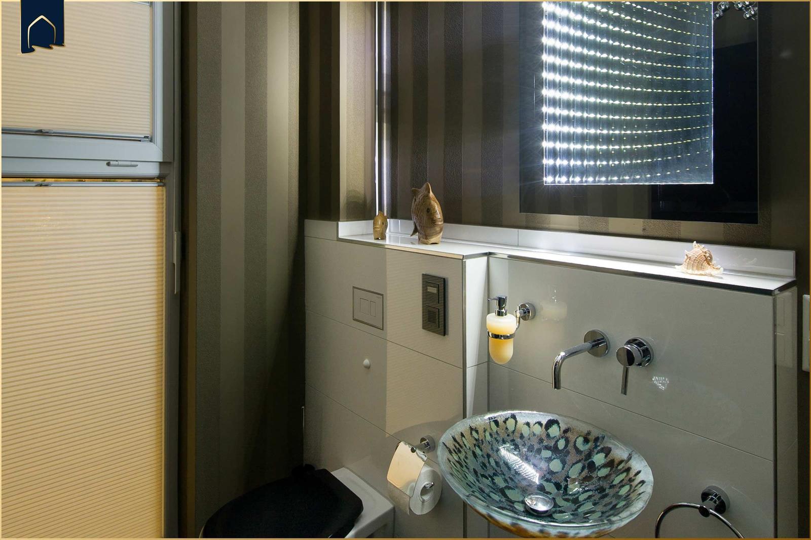 Badezimmer mit Waschbecken, Spiegel und Toilette