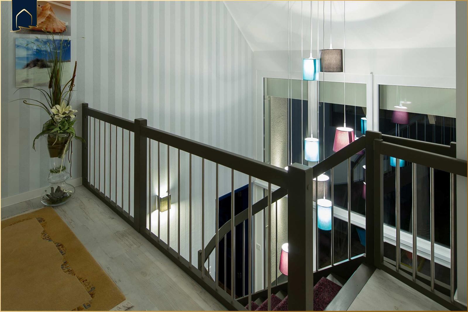 Haus mit Holzgeländer und bunten Hängelampen im Flur