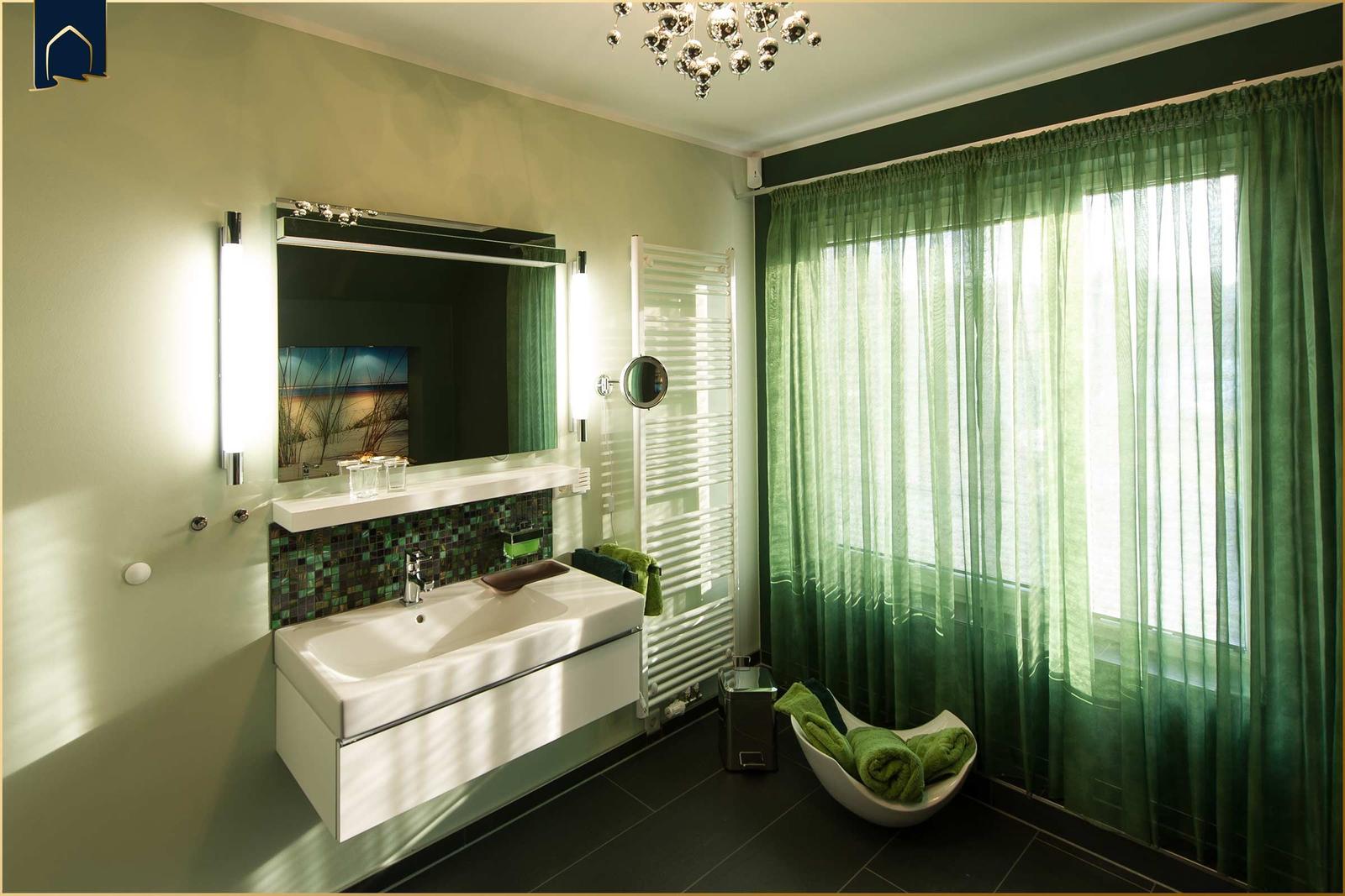 Badezimmer mit grünen Vorhängen, Waschbecken und Spiegel