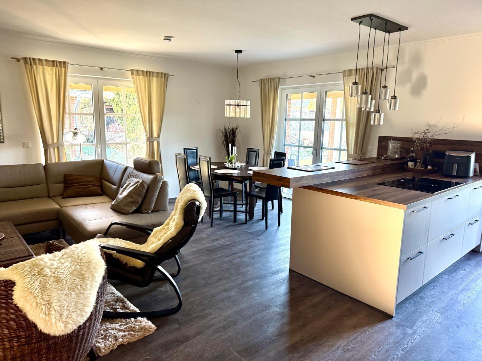 Raum mit gemütlicher Sitzecke und 65 Zoll TV Offener Küche mit Tresen und Kochinsel. Essecke mit 6 Plätzen. Blick auf die Felder. und d...