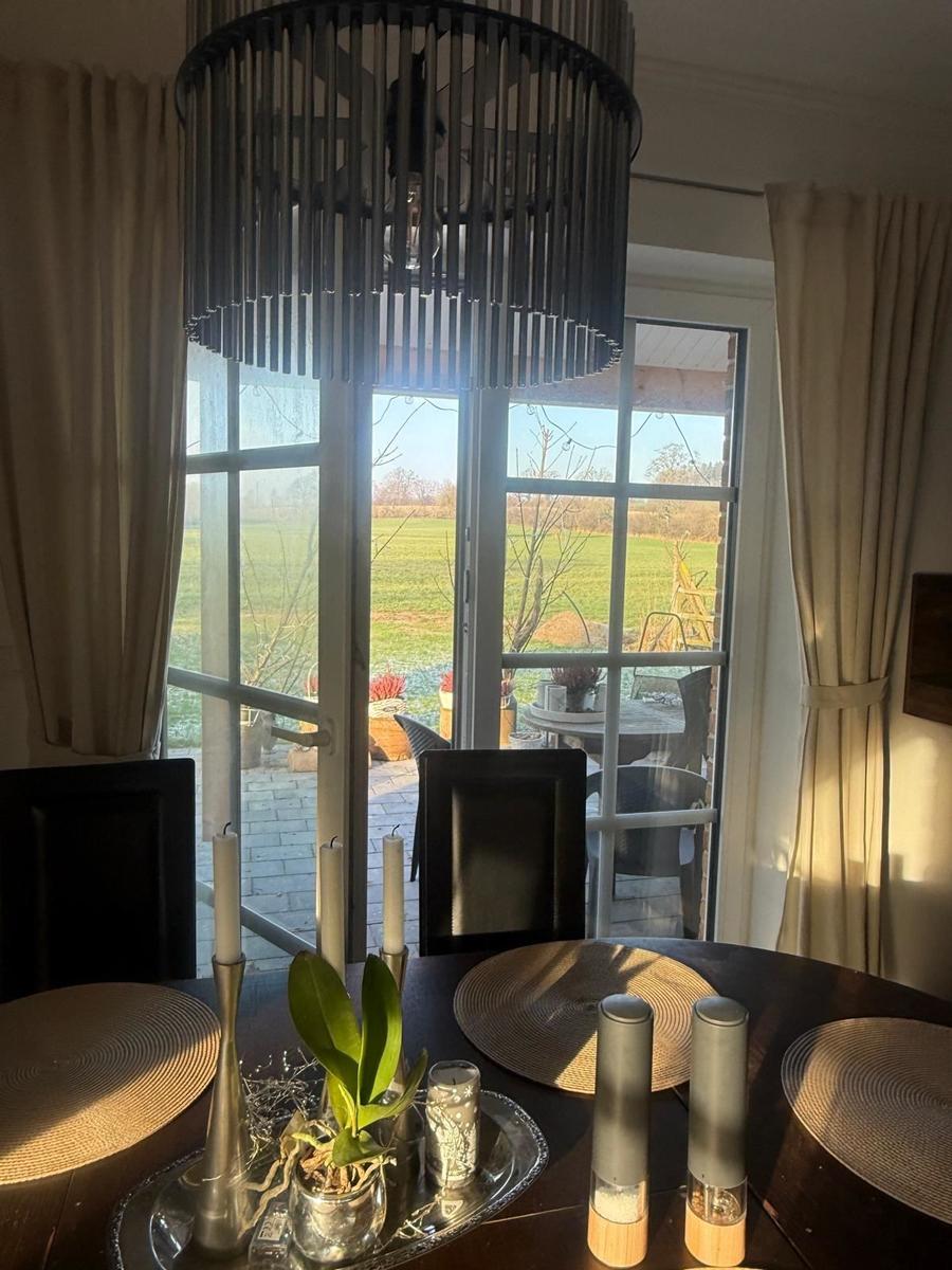 Raum mit gemütlicher Sitzecke und 65 Zoll TV Offener Küche mit Tresen und Kochinsel. Essecke mit 6 Plätzen. Blick auf die Felder. und d...