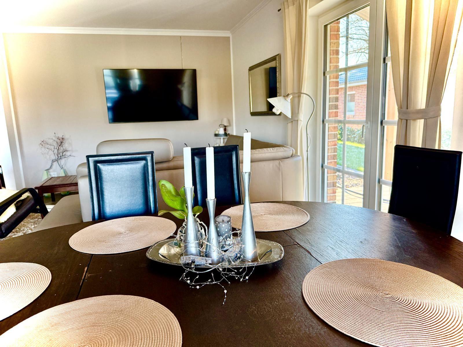 Raum mit gemütlicher Sitzecke und 65 Zoll TV Offener Küche mit Tresen und Kochinsel. Essecke mit 6 Plätzen. Blick auf die Felder. und d...