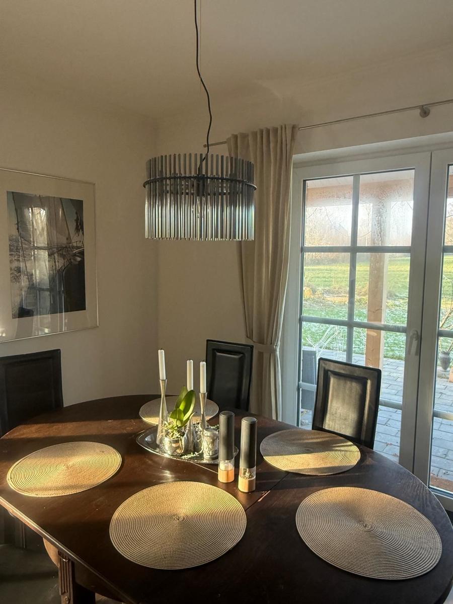 Raum mit gemütlicher Sitzecke und 65 Zoll TV Offener Küche mit Tresen und Kochinsel. Essecke mit 6 Plätzen. Blick auf die Felder. und d...