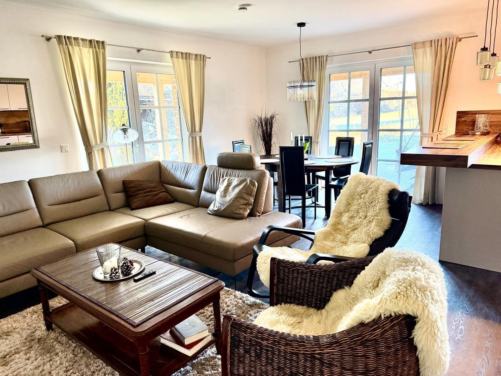 Raum mit gemütlicher Sitzecke und 65 Zoll TV Offener Küche mit Tresen und Kochinsel. Essecke mit 6 Plätzen. Blick auf die Felder. und d...