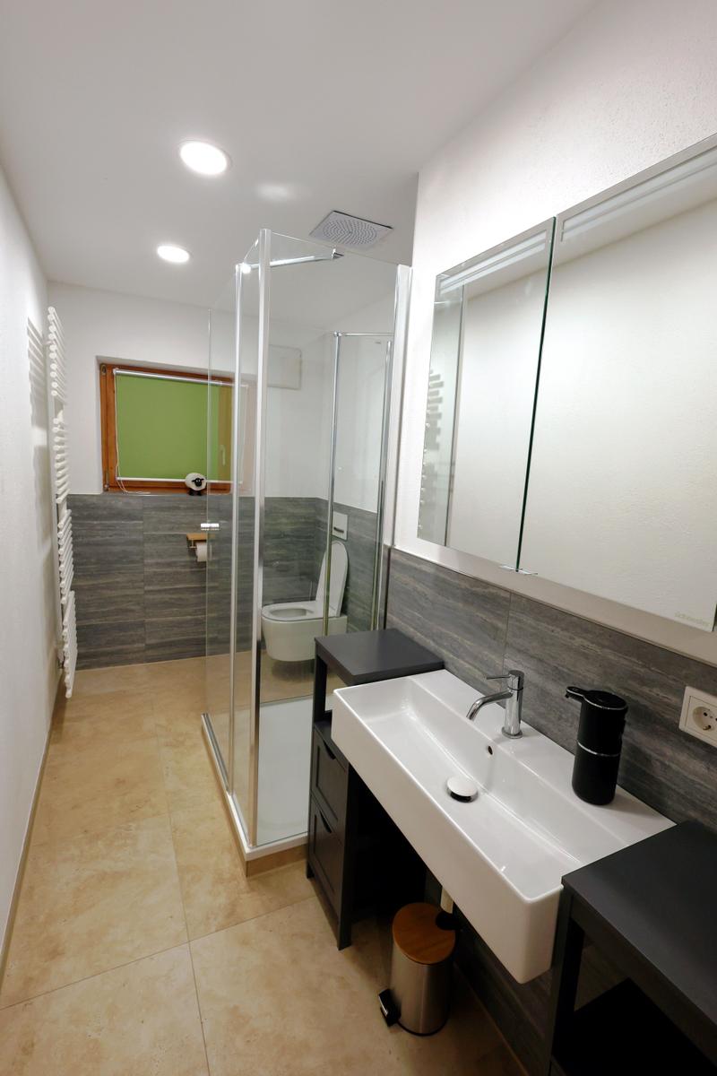 Badezimmer mit Dusche, Waschbecken und Toilette