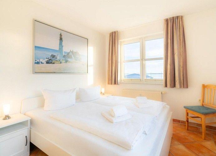 Schlafzimmer mit Doppelbett, Fenster und Wandbild