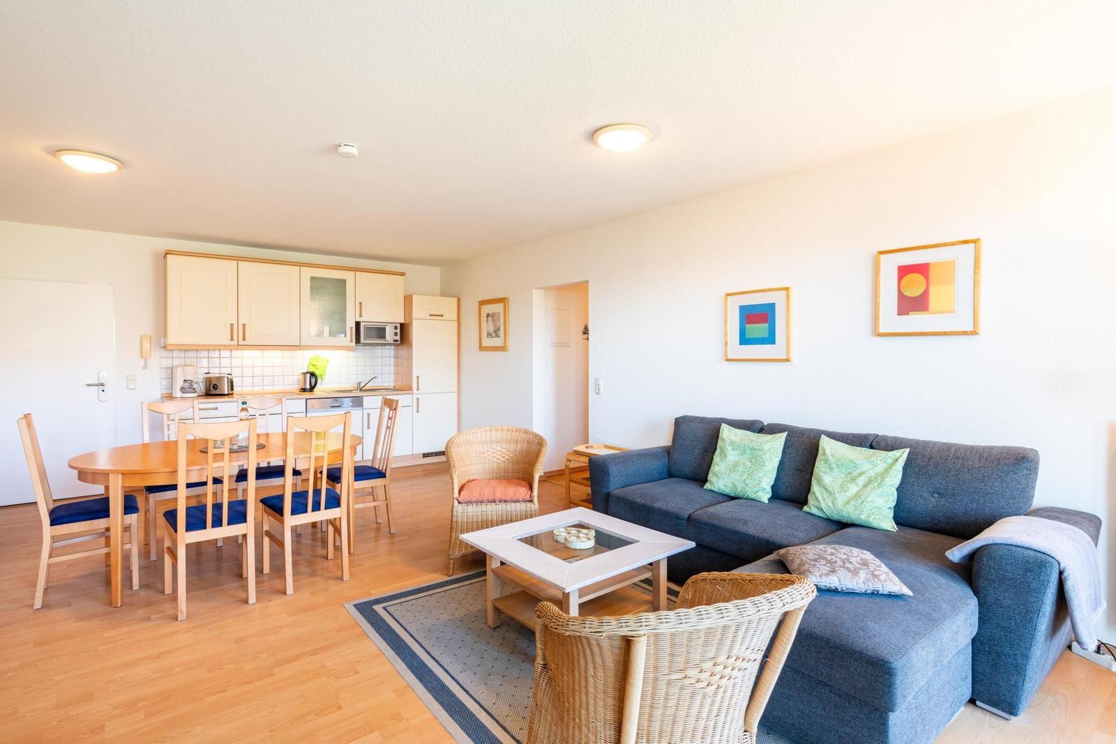 Wohn- und Essbereich mit Sofa, Esstisch und Küche.