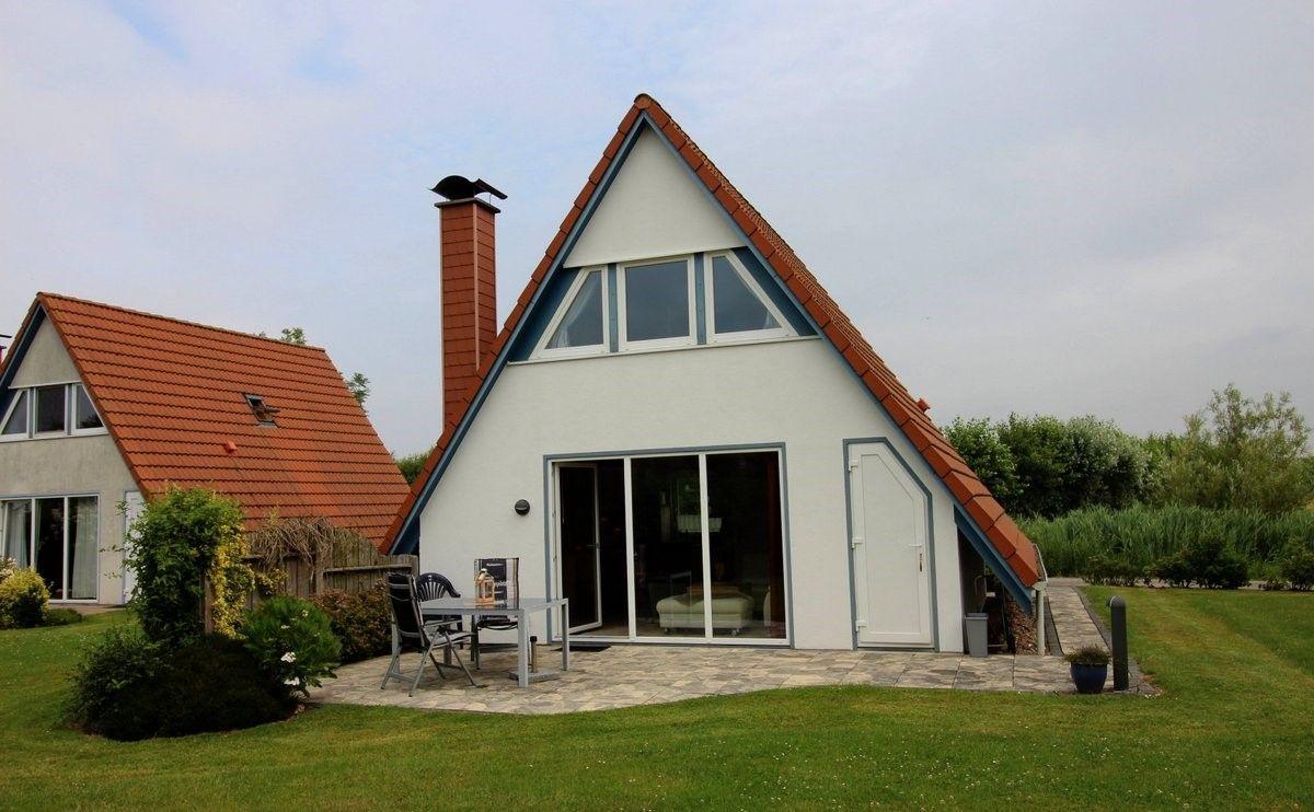 Wohnhaus mit Terrasse und Garten. Große Glastüren führen ins Innere.