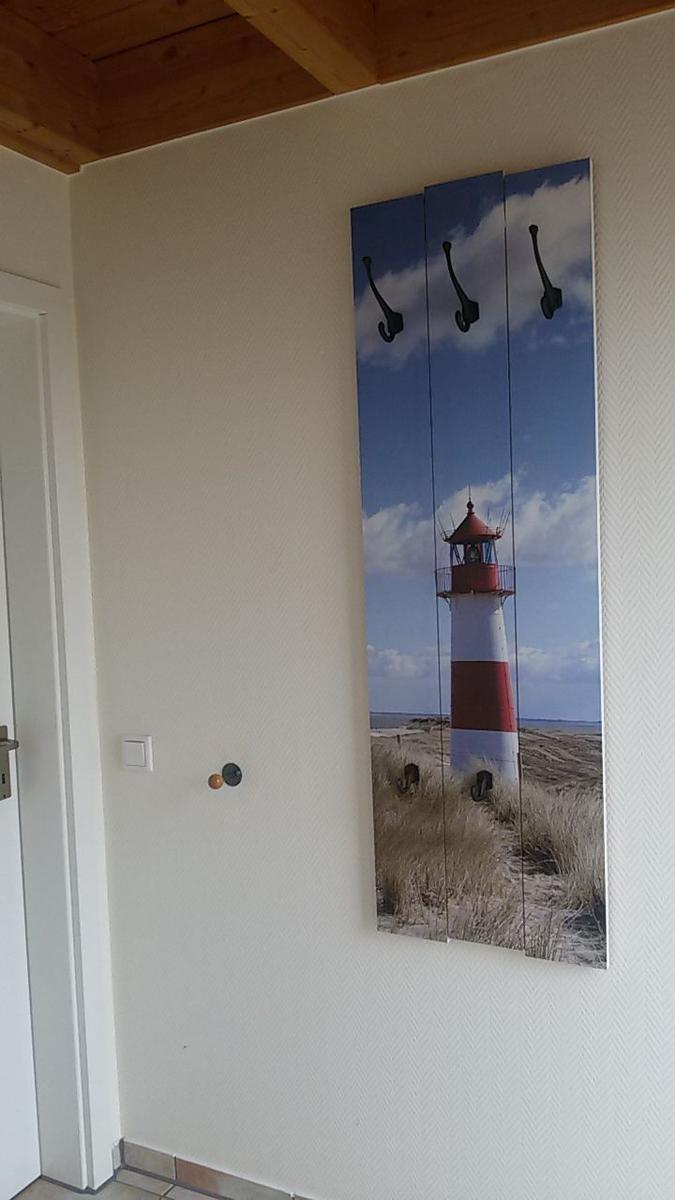 Wand mit Leuchtturm-Bild und Haken