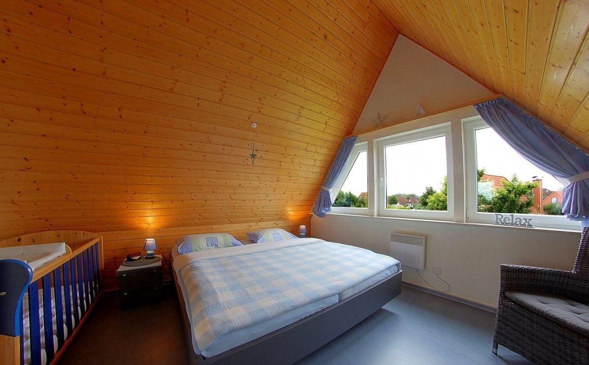 Schlafzimmer mit Doppelbett, Kinderbett und Fenster mit Blick.