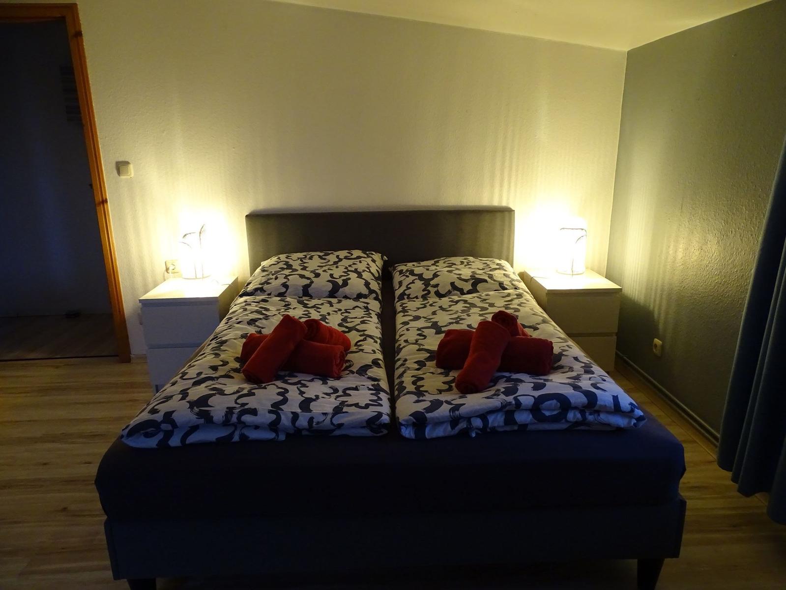 Schlafzimmer mit Doppelbett, zwei Nachttischen und Lampen.