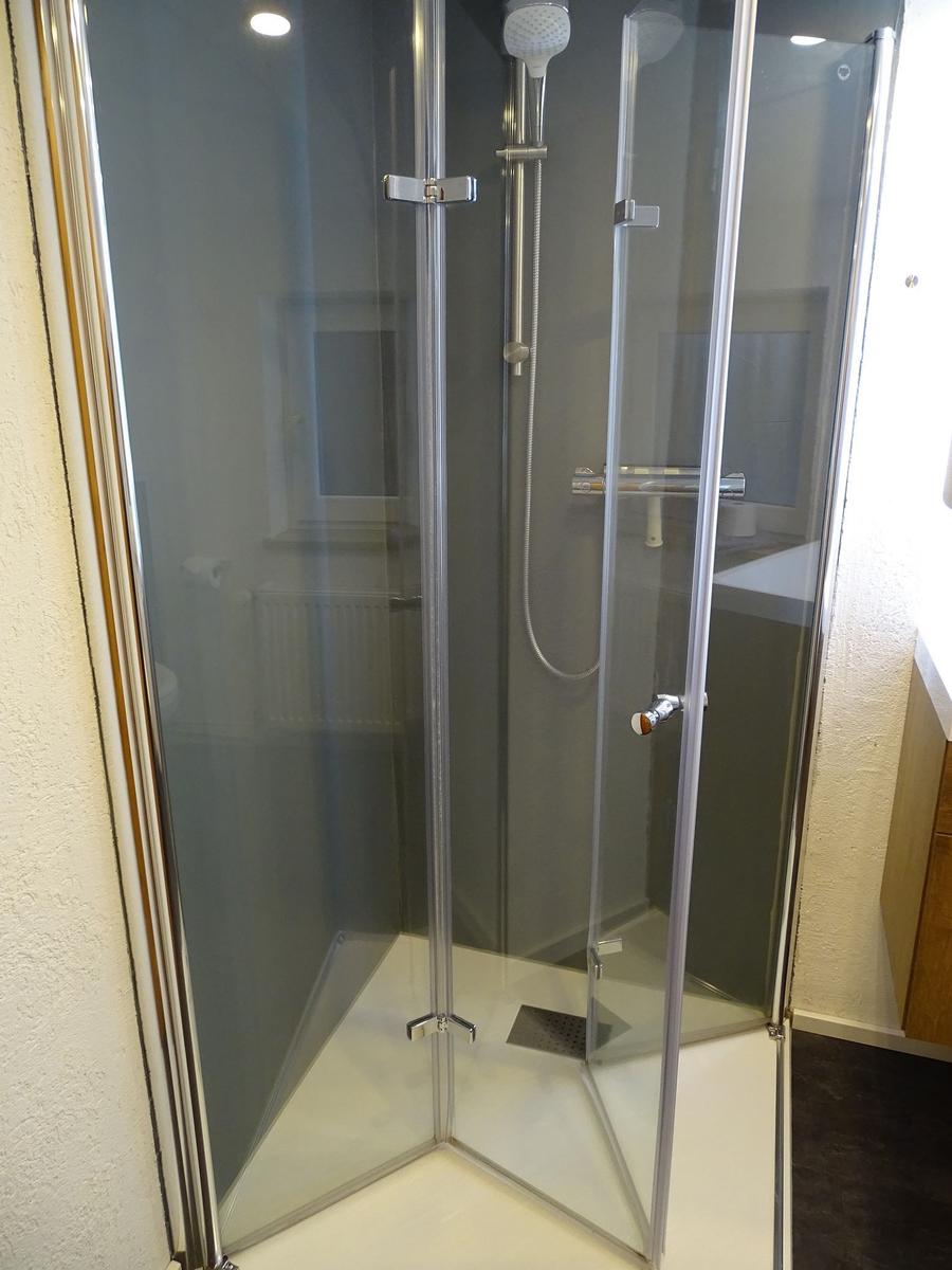 Duschkabine mit Glaswänden und Handbrause