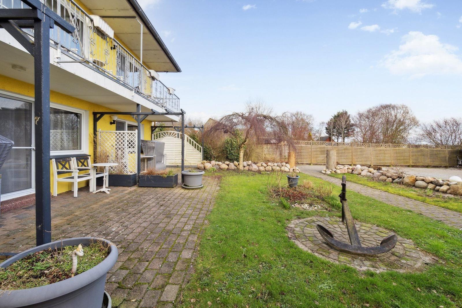 Haus mit Terrasse, Garten und Anker im Vorgarten.
