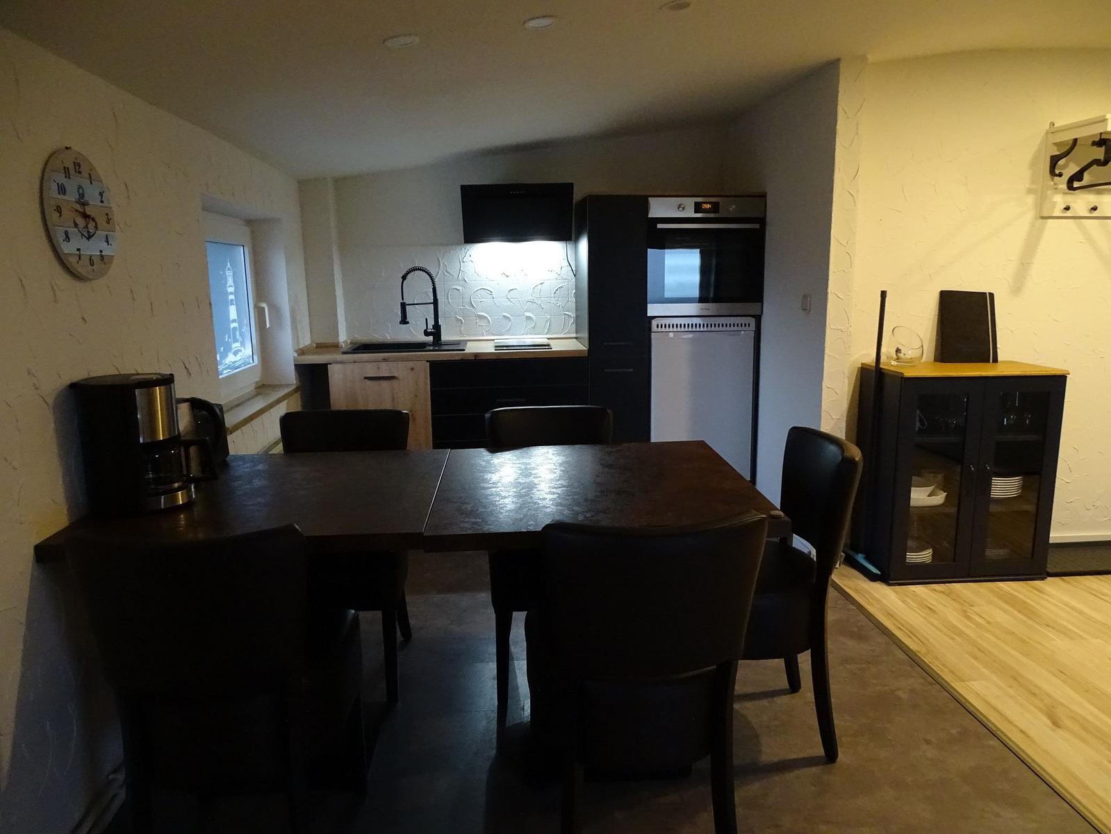 Essbereich mit Küchenzeile und Tisch für sechs Personen.