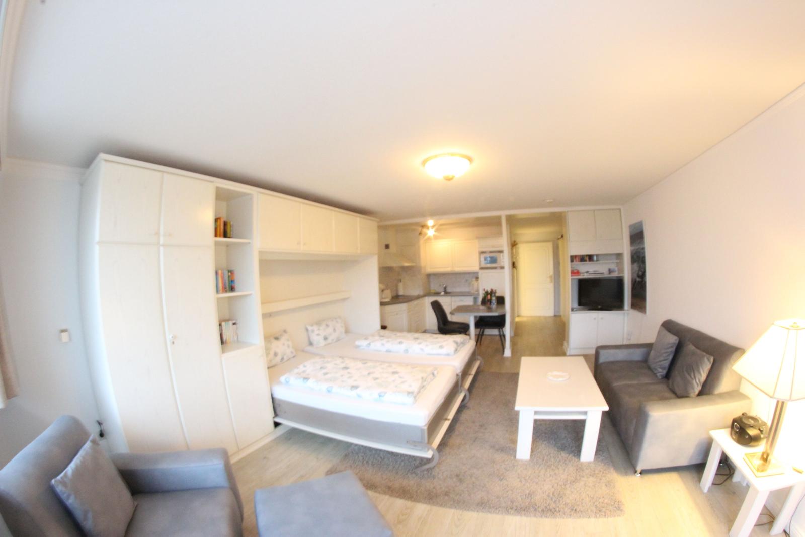 Wohnung mit Schlafzimmer, Wohnbereich und Küche.