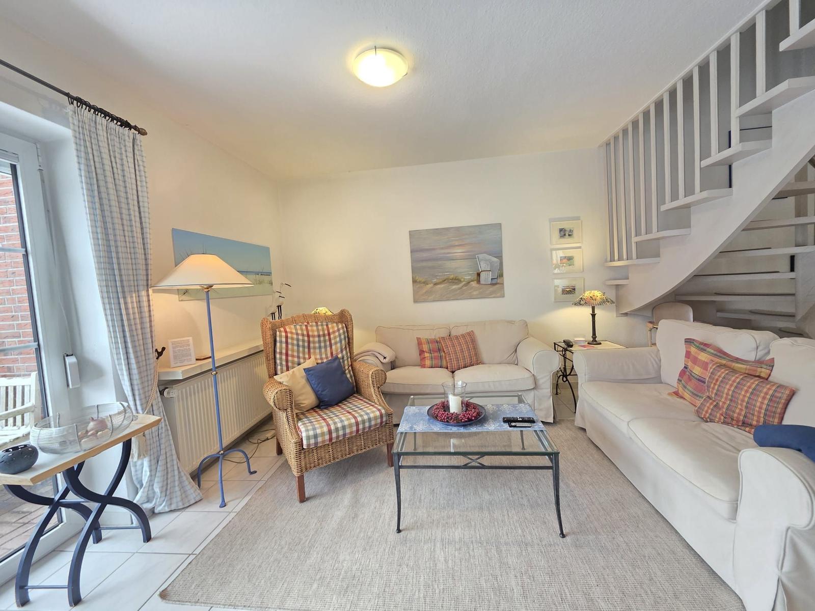 Living room with two sofas, a chair, and a staircase.