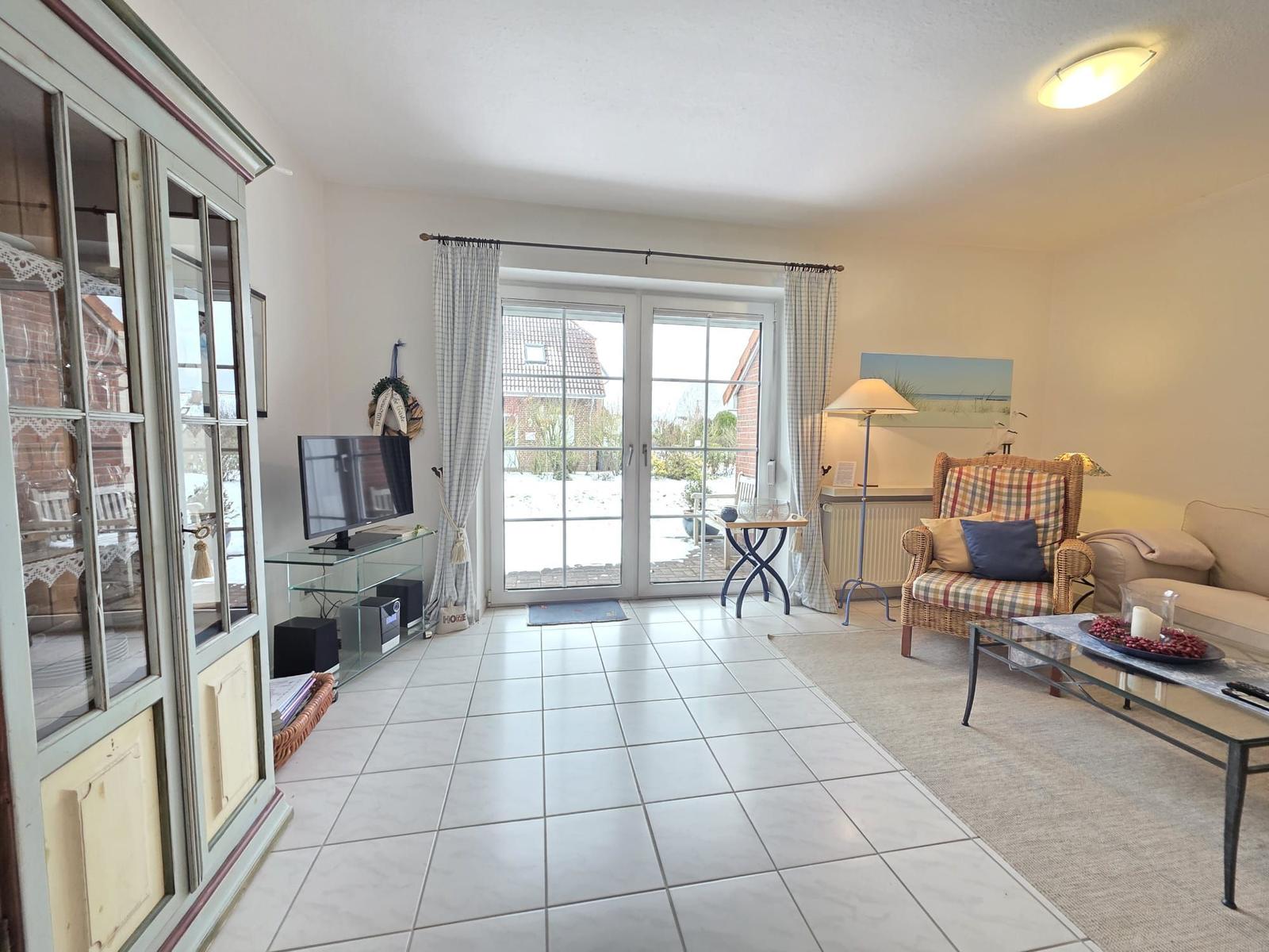 Living room with sliding glass doors, TV, and seating.