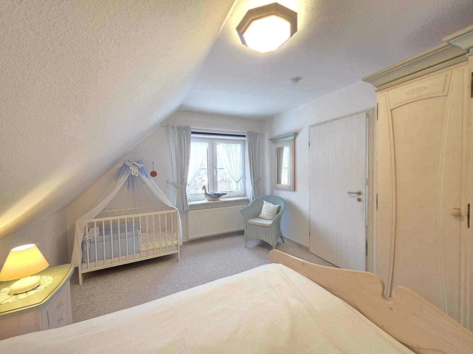 Bedroom with crib, bed, and wardrobe