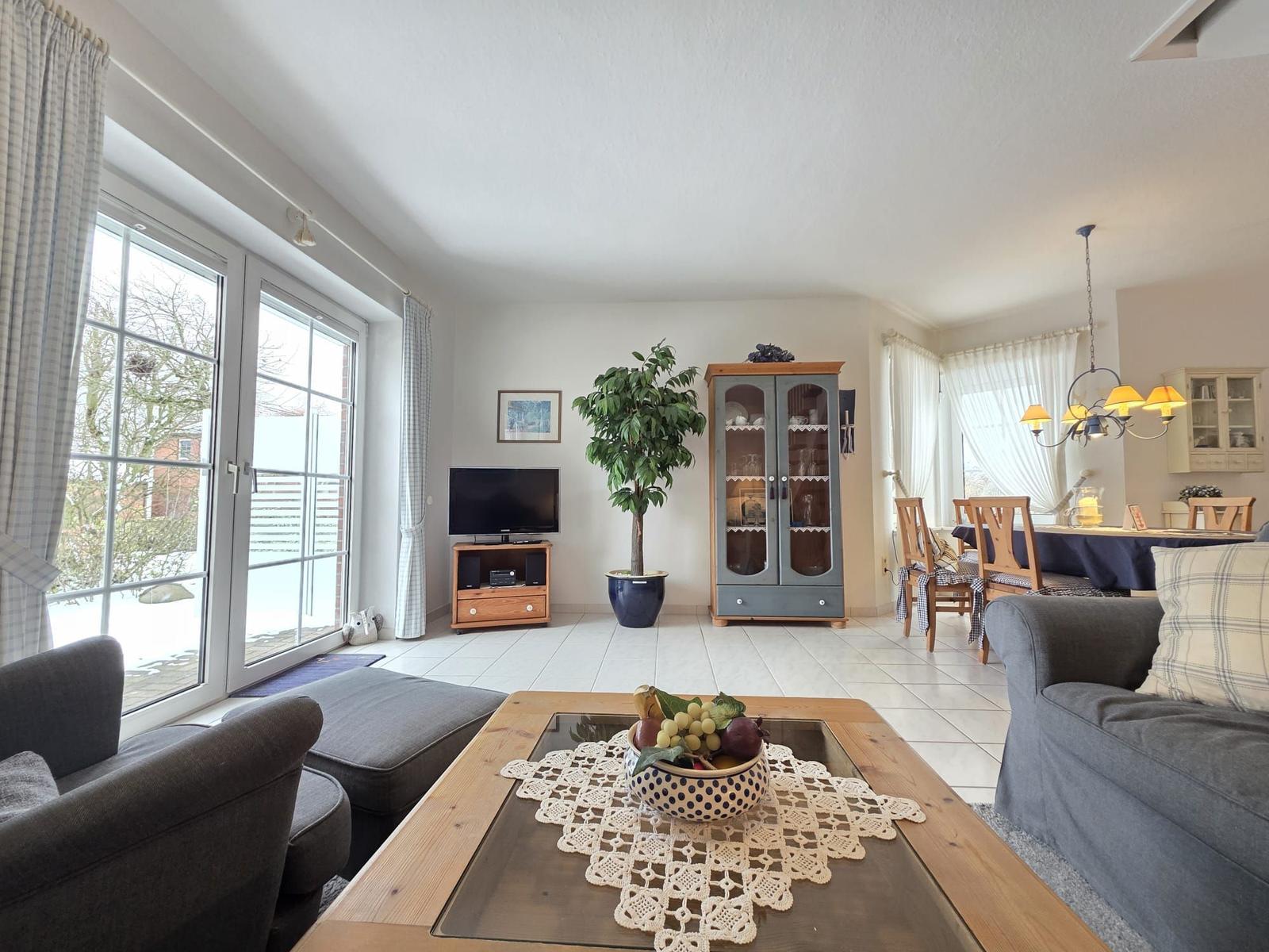 Living and dining area with sofa, coffee table, and TV.