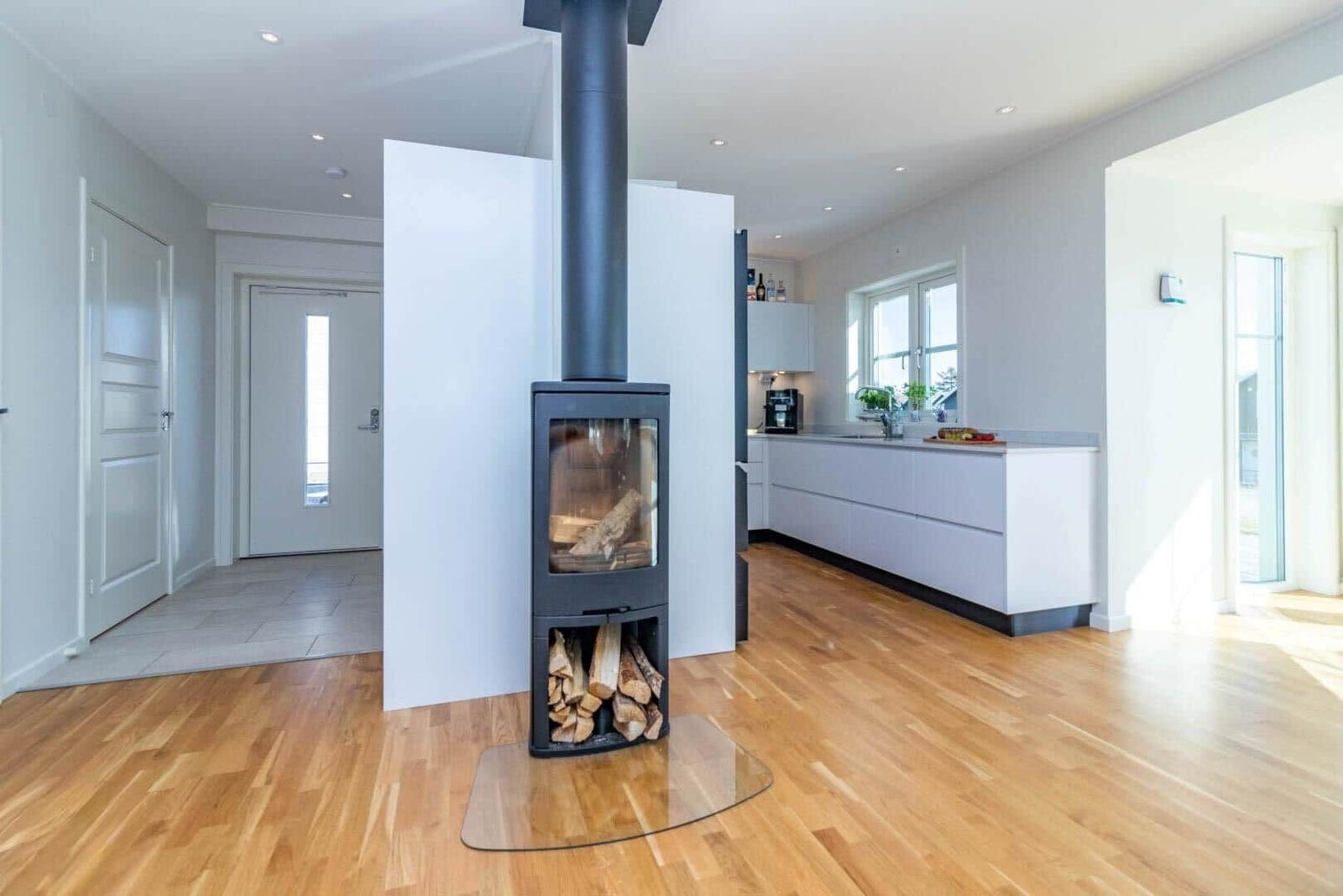 Moderne Küche mit Holzboden und Kaminofen im Zentrum.