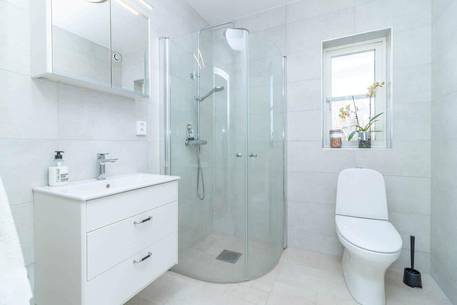 Badezimmer mit Dusche, Waschbecken und Toilette