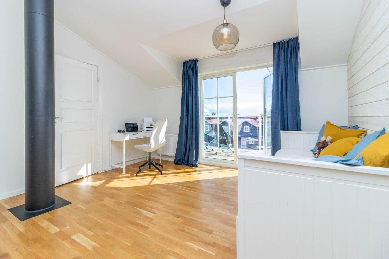 Schlafzimmer mit Fenster, Schreibtisch und Kaminrohr