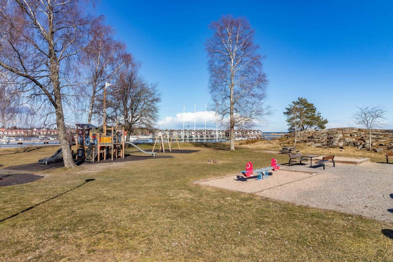 Kinderspielplatz mit Rutsche und Schaukel am Wasser