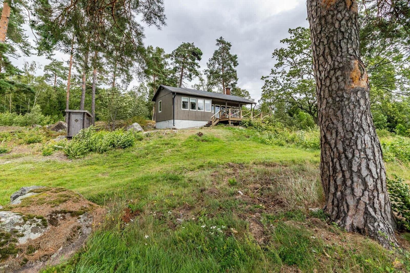 Holzhütte mit Balkon in grüner Waldlandschaft