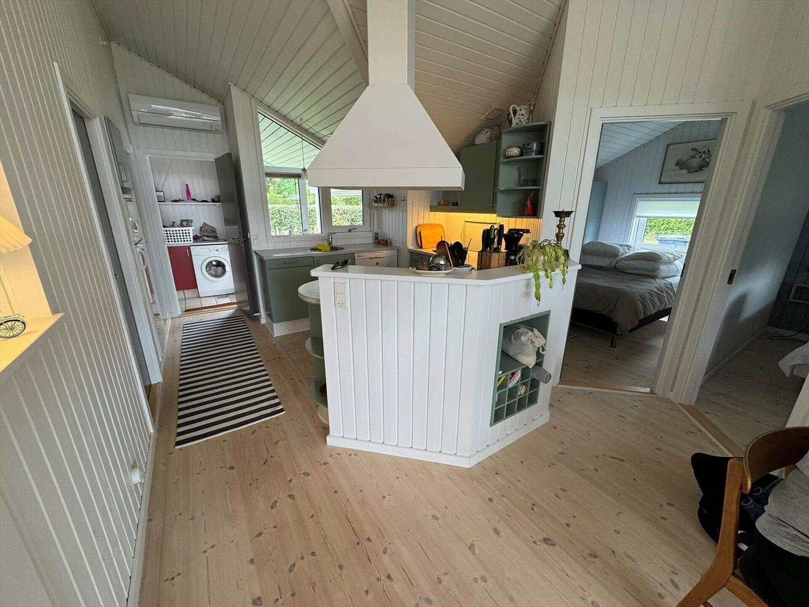 Kitchen with island, bedroom and laundry room visible.