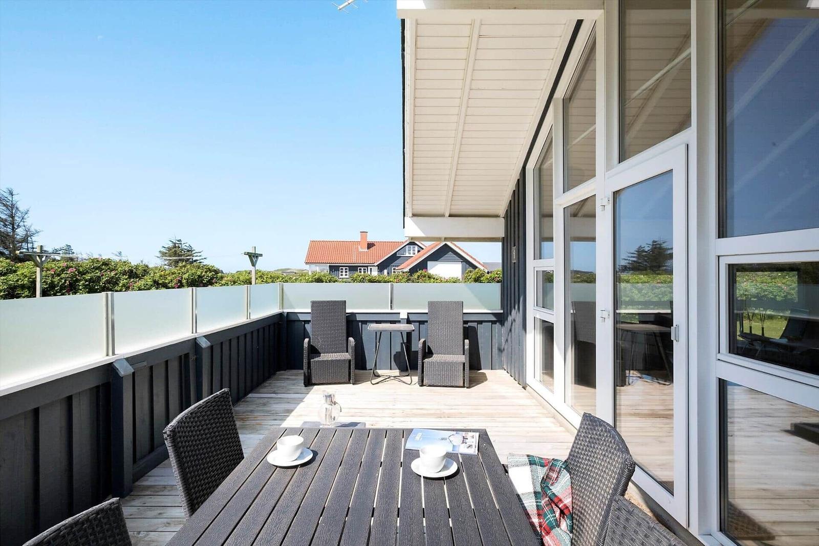 Terrasse mit Tisch, Stühlen und Blick auf Häuser.