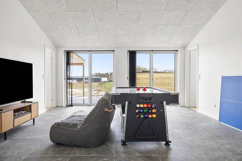 Raum mit Billardtisch, Fernseher und großem Fenster zur Aussicht