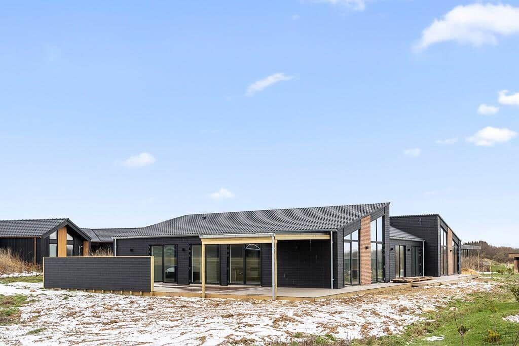 Moderne Villa mit Glasfassade und Terrasse im Freien.
