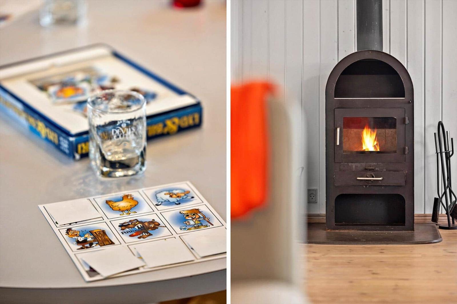 Table with game and glass next to fireplace with burning wood stove.