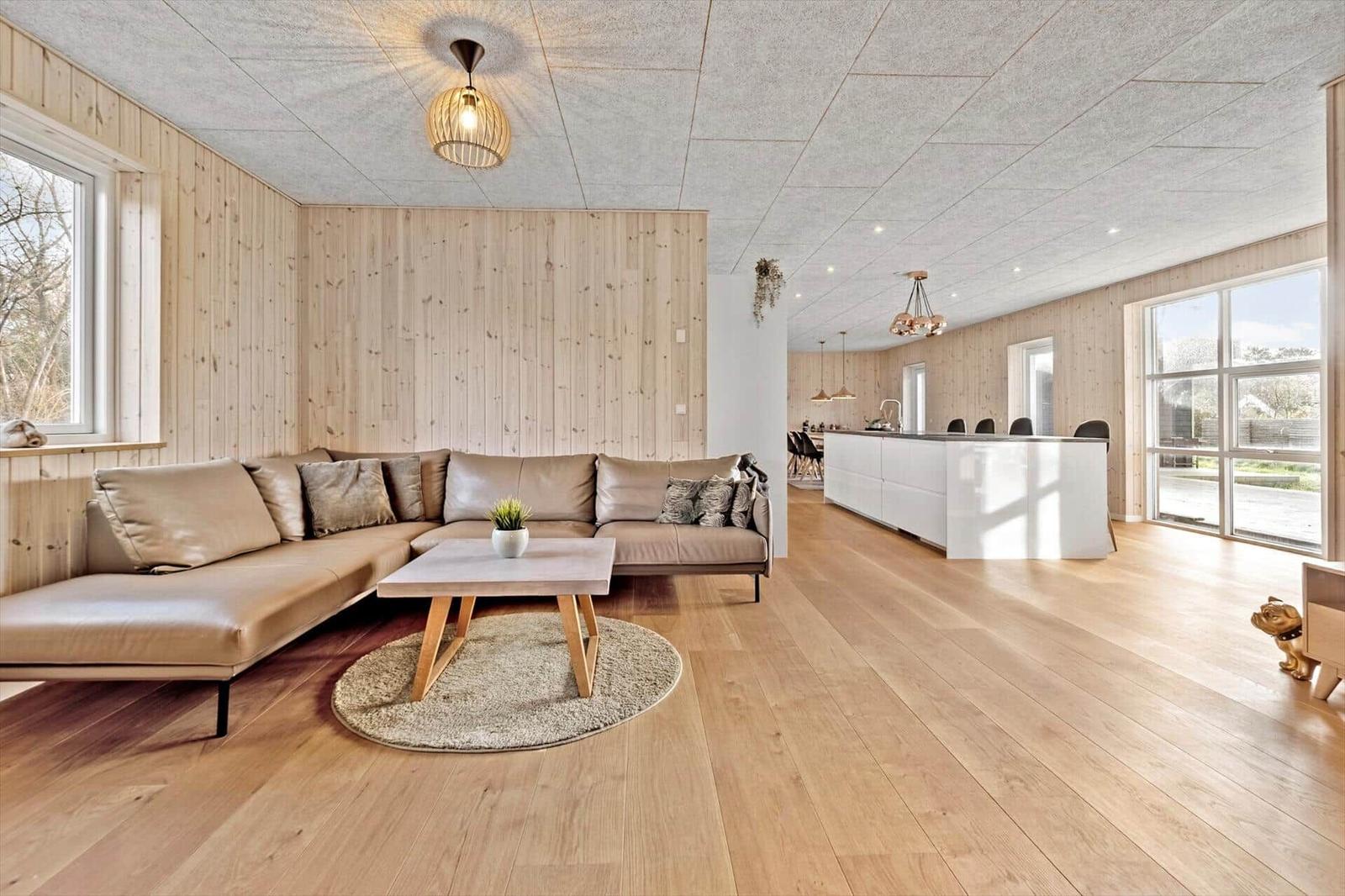 Wohn- und Essbereich mit Sofa, Couchtisch und Kücheninsel.