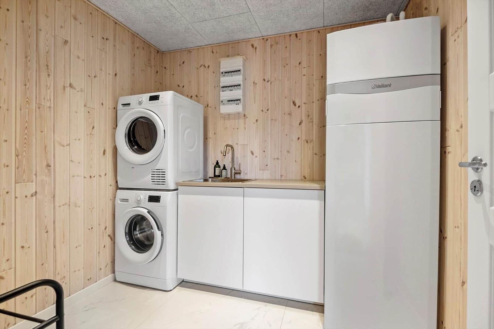 Wäscherei mit Waschmaschine, Trockner und Spüle an Holzwand